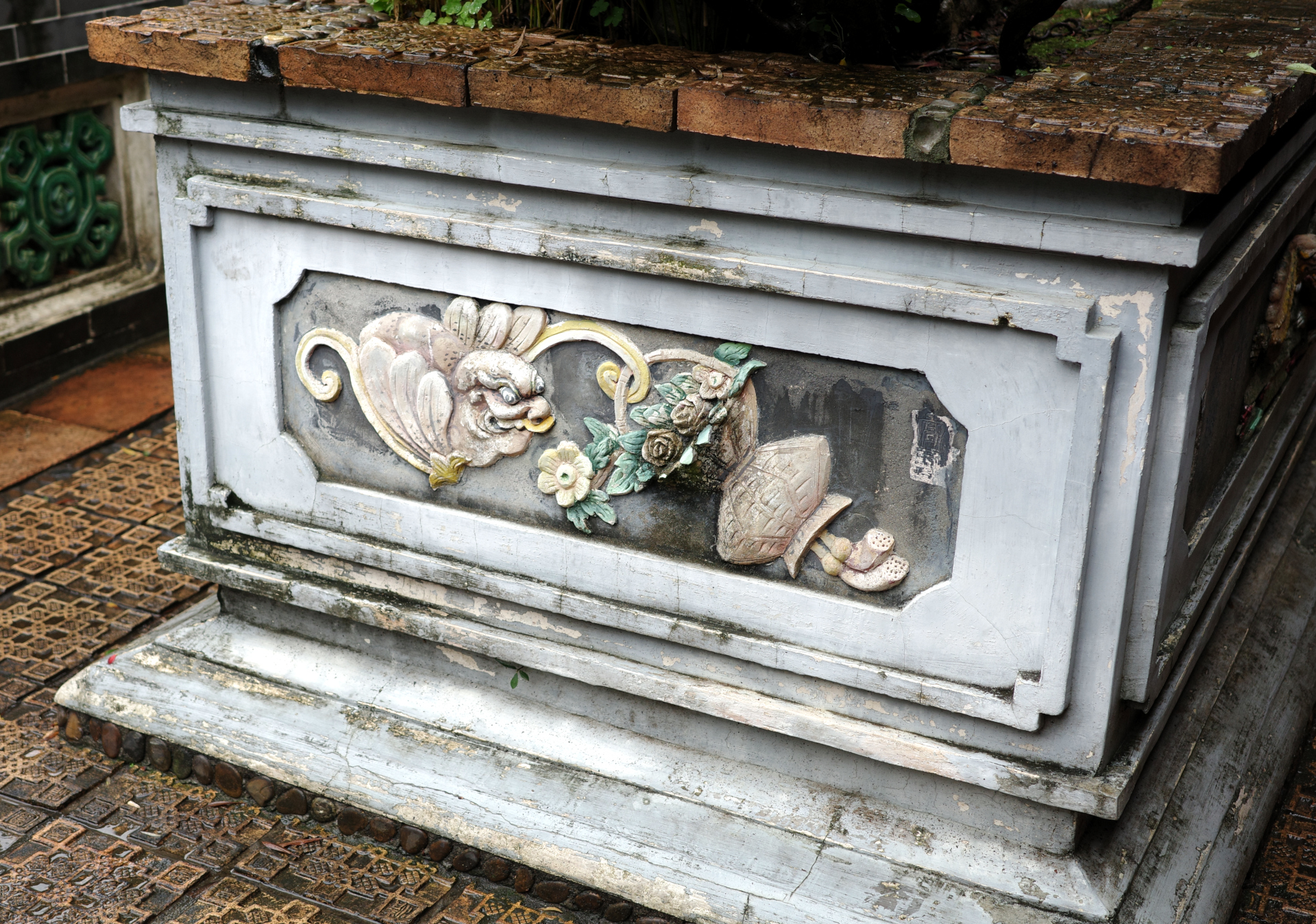 A decoration on the side of a stone garden bed